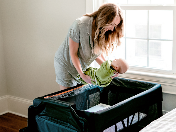 Mom putting baby in 4moms Breeze® Plus Playard